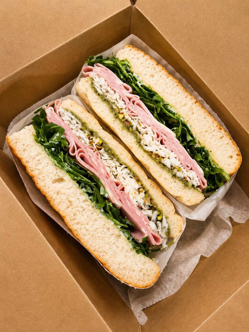 Two Italian deli sandwiches in a kraft box at Vici Café