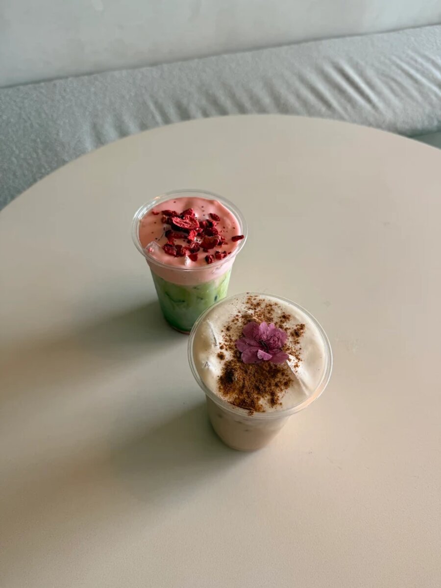 Two matcha lattes topped with real edible flowers